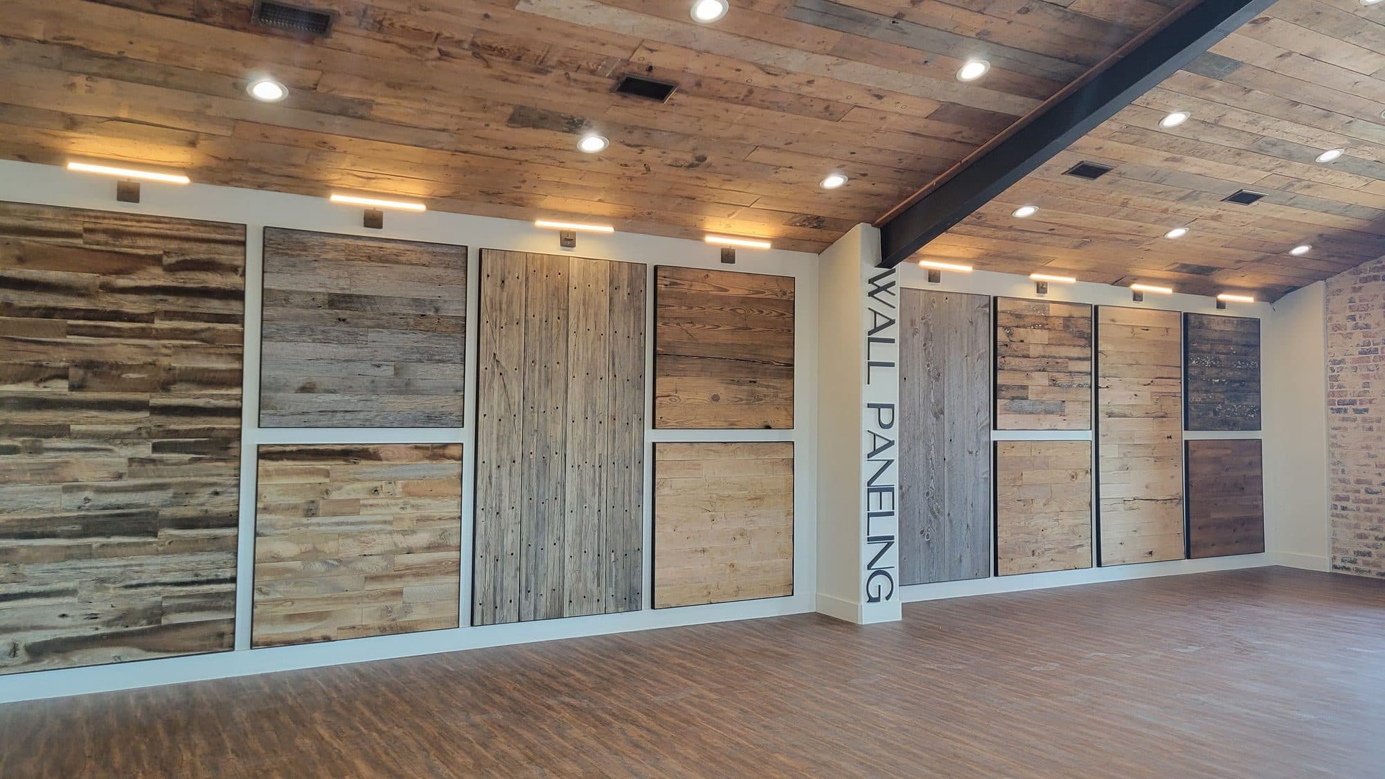 Reclaimed wood wall paneling samples displayed under a barn wood ceiling