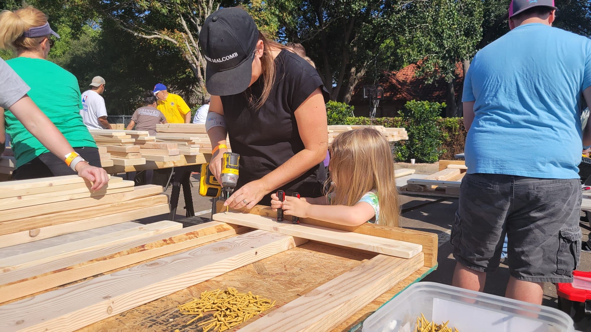 Savana and a young helper driving screws together at a community build day