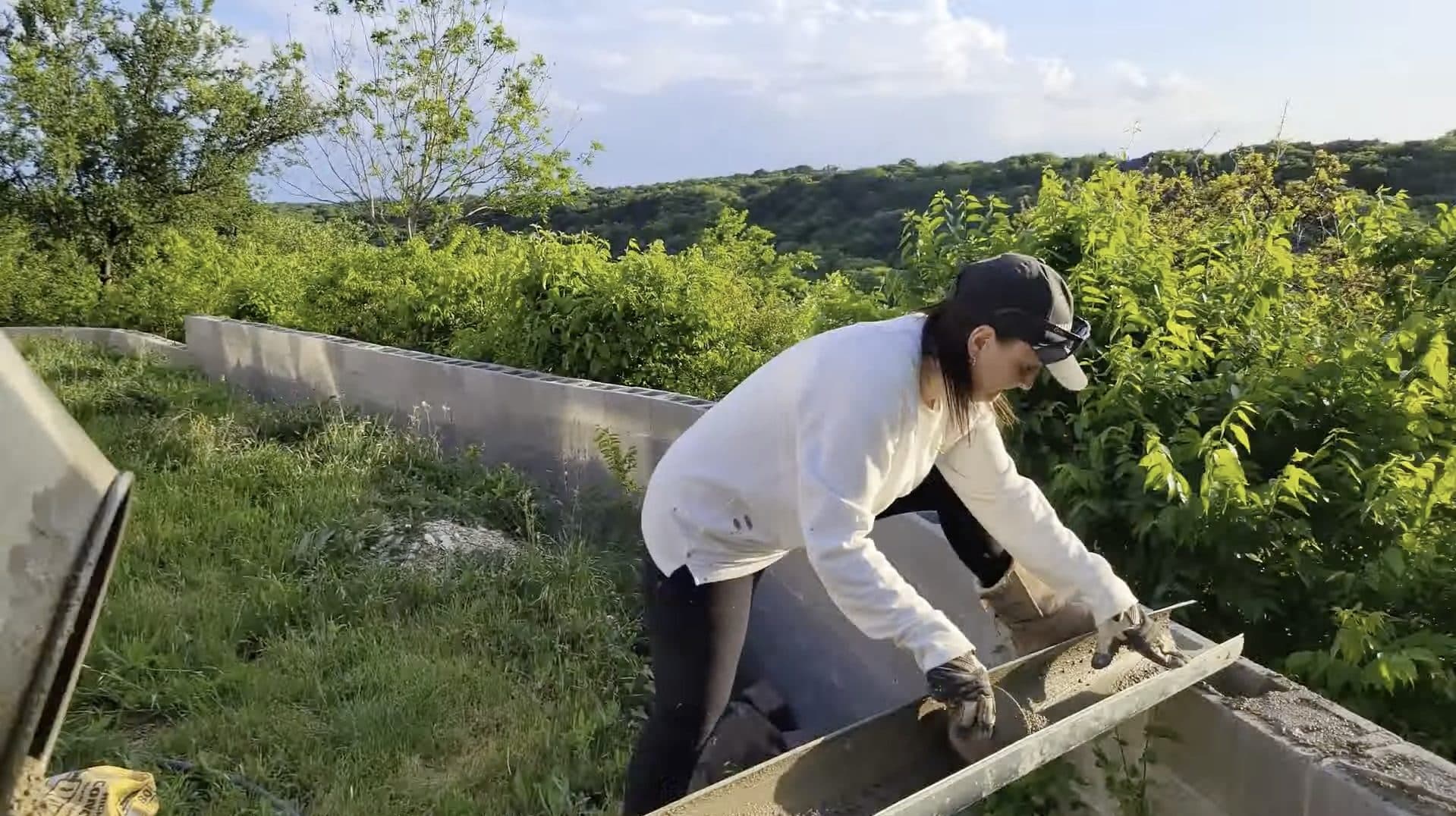 Savana smoothing freshly poured concrete on an outdoor wall