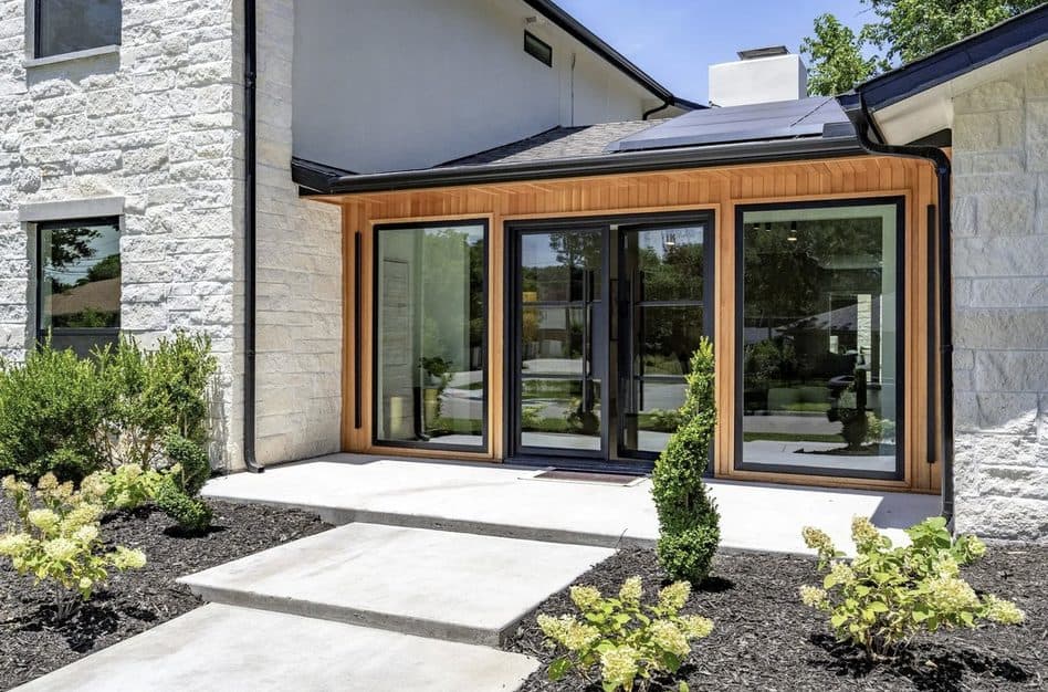 Cedar-clad entry addition with floor-to-ceiling glass and new landscaping