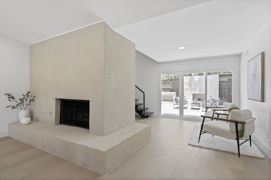Sculptural plaster fireplace with a wraparound hearth