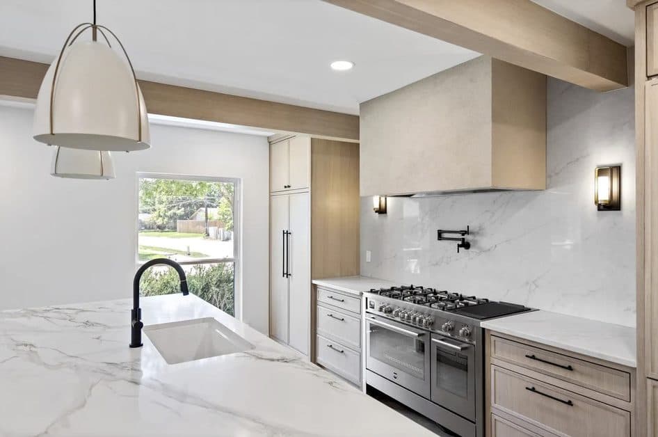 Marble-look backsplash, plaster range hood, and white oak cabinets