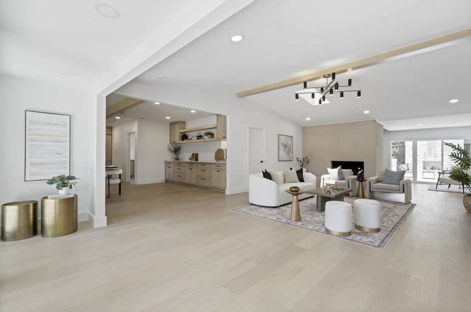Bright open living room with light oak floors and a plaster fireplace