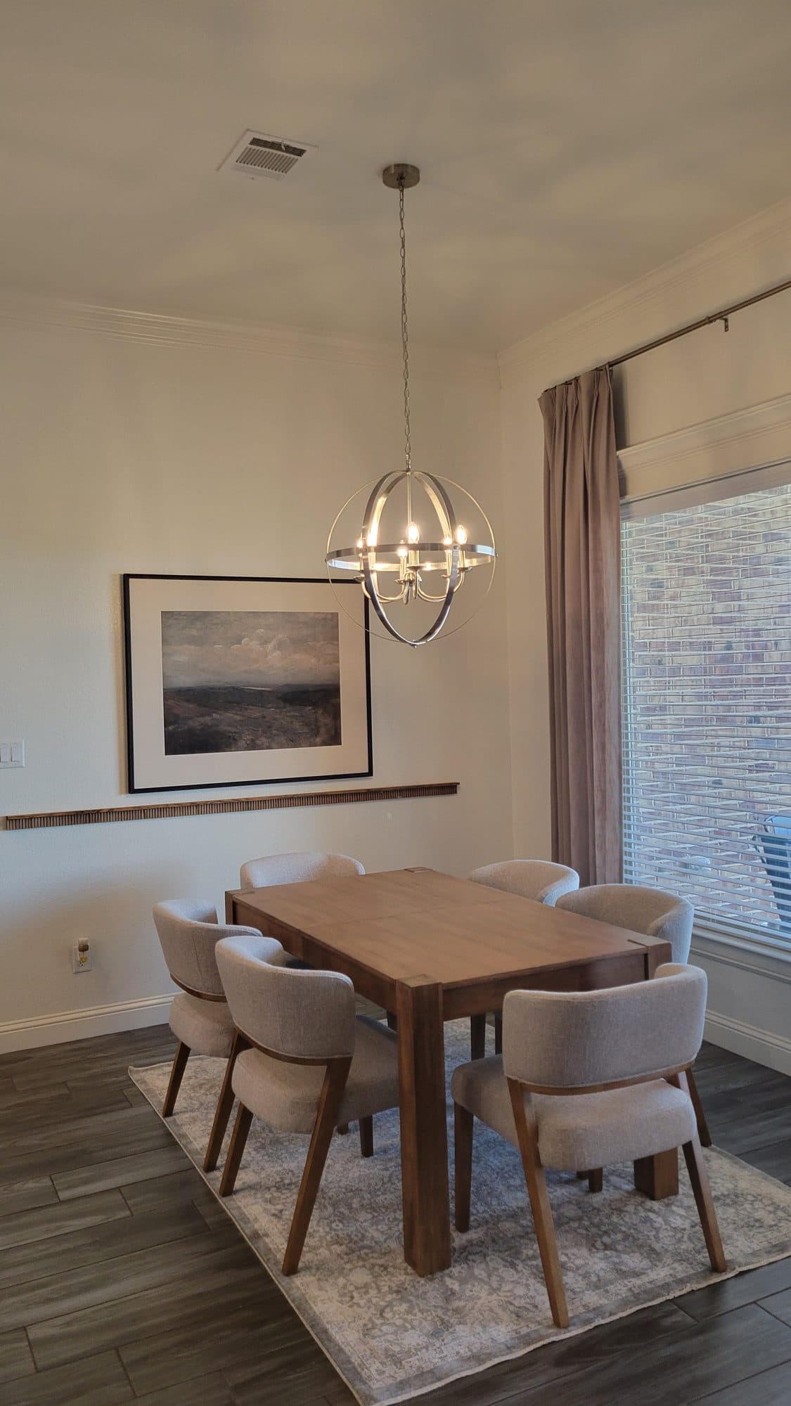 Dining area beside a tall window with blush drapery